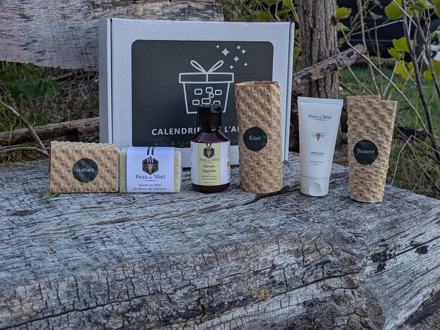 Contenu du Coffret Sept Mots sorti de sa boîte devant un van : pot de miel, savon, tube de crème et étuis